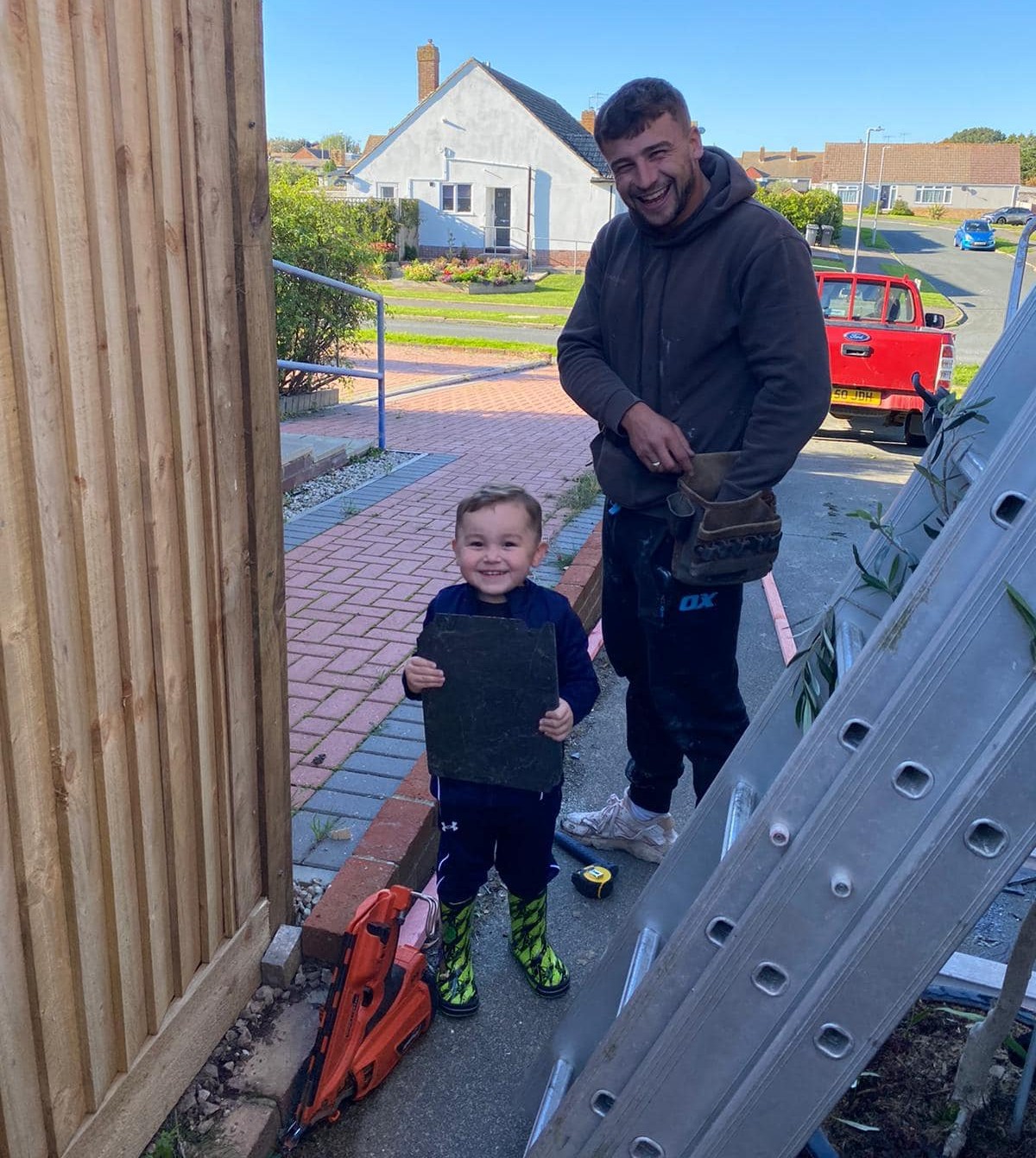 A C&C Roofing roofer with a young helper on a job site
